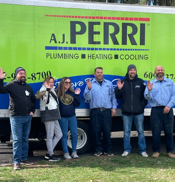  Six A.J. Perri team members wave while standing in front of a bright green A.J. Perri service truck.