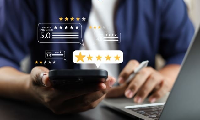 Person using smartphone and laptop with floating five-star customer review icons representing high satisfaction and ratings.